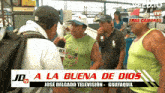 a group of men standing in front of a sign that says jd a la buena de dios jose delgado television guayaquil
