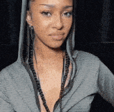 a woman with braids is wearing a hooded jacket