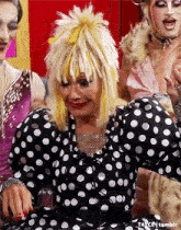a woman wearing a black and white polka dot dress with yellow hair