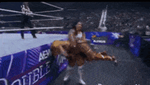 two women are wrestling in a ring with a purple banner that says aew on it