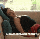 a woman is laying on a couch with the words anna e arrivato pranzy below her