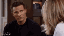 a man and a woman are sitting next to each other and talking to each other .