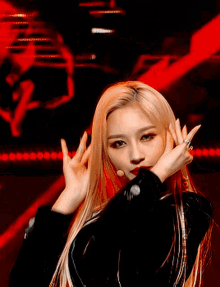 a woman with long blonde hair is wearing a black jacket