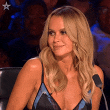 a woman is sitting in front of a microphone wearing a black and blue top