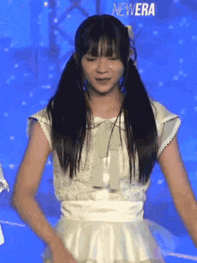 a girl in a white dress is standing in front of a sign that says new era