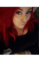a woman with red hair has a tattoo on her hand that says " i love you "