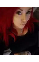 a woman with red hair has a tattoo on her hand that says " i love you "