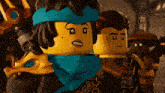a group of lego figures are standing together and one has a scarf around her neck