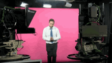 a man stands in front of a pink screen that says telescript on it