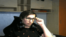 a young man wearing glasses and headphones looks at something