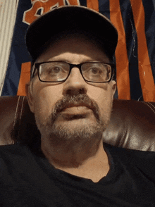 a man wearing glasses and a hat with a bears logo on it