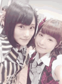 two girls are posing for a picture together and one of them is wearing a striped shirt