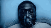 a man in a hospital bed with an oxygen mask on his face .