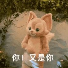 a stuffed animal in a fox costume is standing next to a body of water and holding a light .