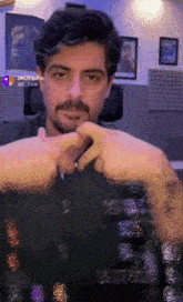 a man with a beard and mustache is making a heart shape with his hands