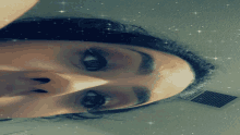 a close up of a woman 's face with stars on the ceiling
