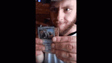 a man wearing headphones holds up a pokemon card with the website www.bandicam.com at the bottom