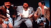 three men in suits and ties are dancing together in a room .