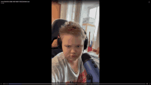 a video of a boy wearing headphones and a microphone is being played