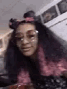 a woman wearing sunglasses and a headband is sitting on a couch in a room .