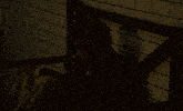 a man in a suit and tie is sitting in a dark room