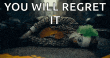 a clown is laying on the ground with the words `` you will regret it '' written on it .