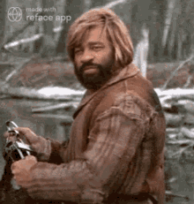 a man with a beard and long blonde hair is holding a gun in a forest .