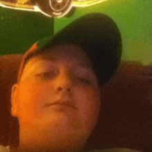 a boy wearing a baseball cap is looking at the camera