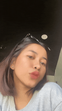 a woman wearing sunglasses takes a selfie with her mouth open