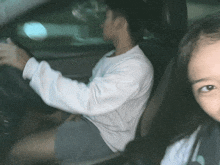 a man is driving a car next to a little girl