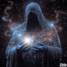 a person in a hooded robe is holding a light in his hands