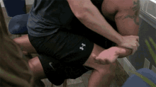 a man wearing under armour shorts is kneeling down