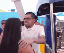 a man in a white shirt is hugging a woman