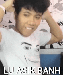 a man wearing a white shirt with lu asik banh written on it