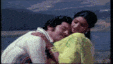 a man and a woman are hugging each other .
