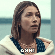 a woman wearing a striped shirt and a gold necklace says ask