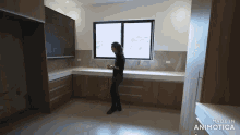 a woman is standing in a kitchen with the words made in animatica on the bottom right