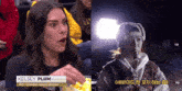 a woman named kelsey plum is eating popcorn