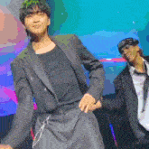 a man in a suit and tie is dancing on a stage