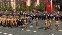 a large group of soldiers marching down a street with a banner that says 1945