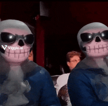 two skeletons wearing sunglasses are standing next to each other with a viggle.ai logo in the background