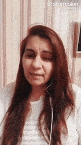 a woman with red hair is wearing headphones and a white shirt that says ' starmaker ' on it