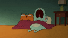 a cat and a dog are laying under a blanket