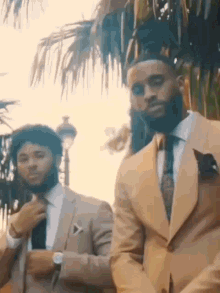 two men in suits are standing next to each other .