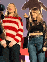 a woman wearing a red and white striped sweater stands next to another woman
