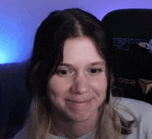a close up of a woman 's face in front of a gaming chair that says ee2