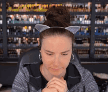 a woman wearing a cat ear headband and earrings