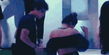 a man and a woman are standing next to each other in a dark room