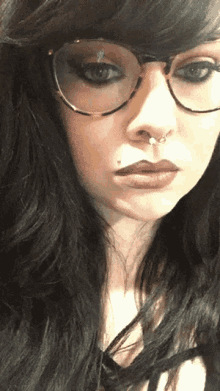a woman with glasses and a nose ring