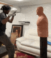 a man wearing boxing gloves stands in front of a mannequin